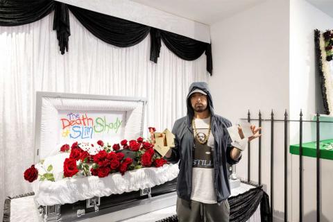 Eminem pictured with two Official Number 1 awards in front of a coffin